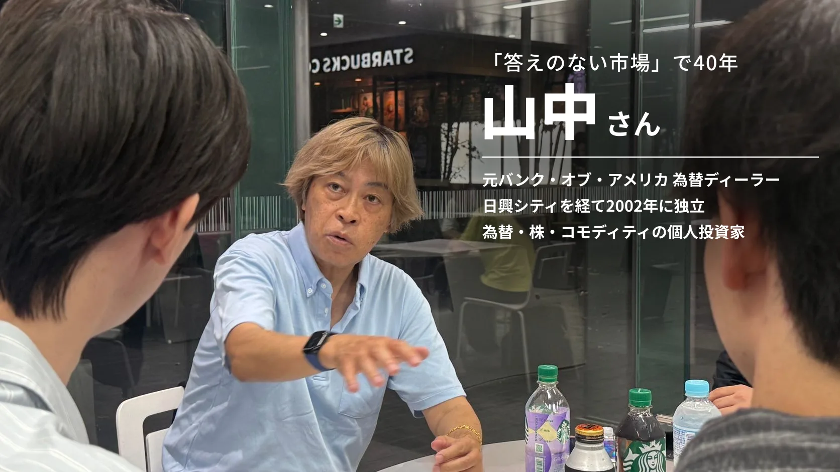 テーブルを囲んだインタビューで、身ぶりを交えて話す山中さん